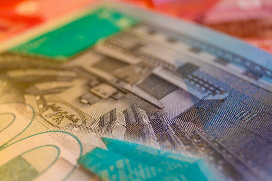 A detailed macro shot of a 200 Ghana Cedi bill, featuring the Parliament House engraving and vibrant teal security accents. The image emphasizes the high-value denomination and its complex textures.
