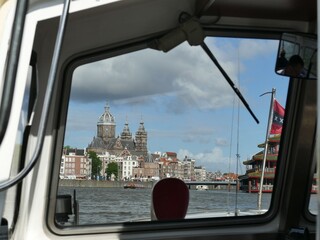 View of Saint Nicholas Church from a boat sailing on the Amstel river in Amsterdam, Netherlands