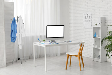 Interior of medical office with doctor's workplace, coat rack and shelf unit