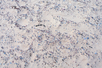 Sandy beach with small pebble rocks in random patterns, as a nature background
