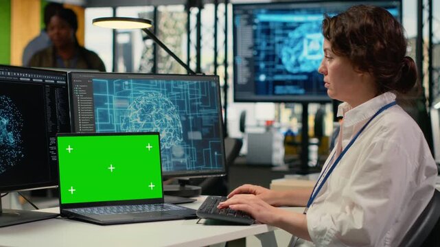 Isolated screen laptop used by admin in office using specialized hardware to accelerate complex AI calculations. IT expert managing deep learning training datasets with chroma key notebook, camera B