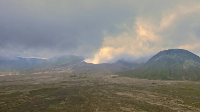Clouds of smoke coming from crater of Mount Bromo and drifting by, Tengger Semeru national park, East Java, Indonesia. Landscape with erupting volcano in sunny day. Eruption and volcanic activity.