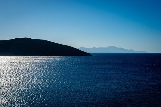 Abstract view of silhouetted Greek islands of Serifos and Sifnos in the Cyclades with sun reflecting of the sea.