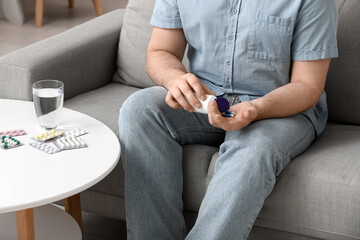 Young man taking pills at home