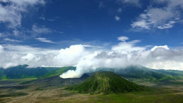 Clouds of smoke coming from crater of Mount Bromo and drifting by, Tengger Semeru national park, East Java, Indonesia. Landscape with erupting volcano in sunny day. Eruption and volcanic activity.