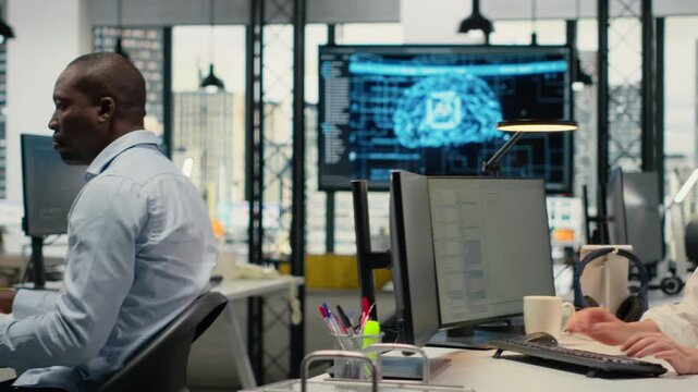 System administrators in office automating workflows using artificial intelligence. IT workers refining machine learning computational models for faster processing, camera B