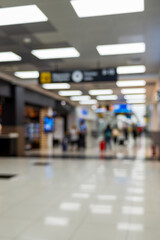 Airport terminal with people and signage. Blurred image. Background.