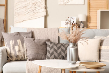 Stylish interior of living room with grey sofa and tables