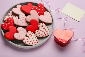 Plate of heart shaped cookies with gift box and envelope on lilac background. Valentine's day...