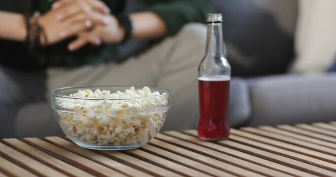 Autofocus is detecting blur and adjusting focus on popcorn and red drink on table for clarity
