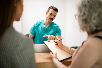 Obraz premium Medical receptionist assisting patient signing health insurance form