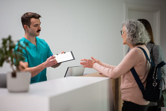 Medical professional assisting senior patient with registration