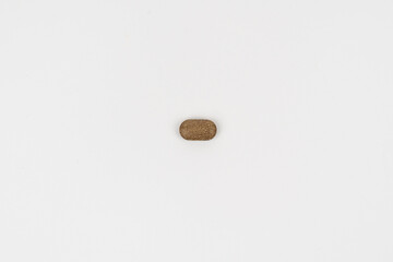 Single Brown Tablet on White Background