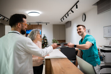 Healthcare team exchanging tablet with senior patient