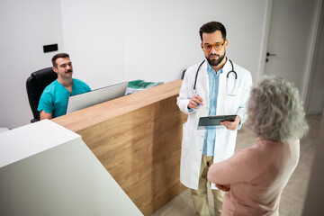 Doctor consulting patient at hospital reception desk