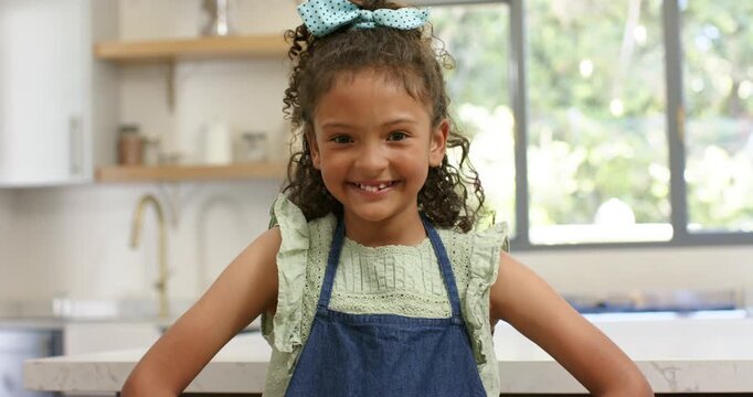 Camera adjusting framing guiding girl crossing arms, tilting head offering smirk at kitchen island