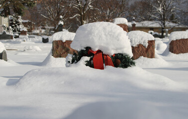 Christmas wreath covered in snow at a small suburban Chicago cemetery