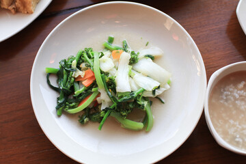 Stir Fried various vegetable served in white plate on wooden table. Chinese food cuisine. 