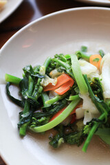 Stir Fried various vegetable served in white plate on wooden table. Chinese food cuisine. 