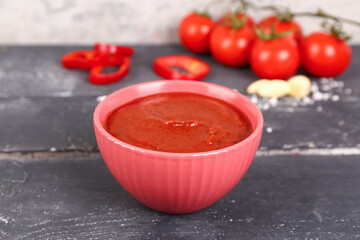 Bowl with tasty tomato paste on table