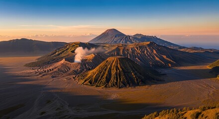 Majestic panoramic sunrise of active Mount Bromo volcano erupting smoke within the vast Tengger caldera, with Mount Semeru in the background, East Java, Indonesia.