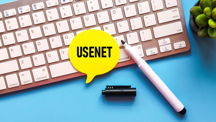 Yellow Speech Bubble with "USENET" Text on a White Computer Keyboard, Representing Early Internet Communication and Forums