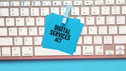 Blue Sticky Notes with "Digital Services Act" Text Clipped to a Computer Keyboard, Representing New Online Regulations and Legislation