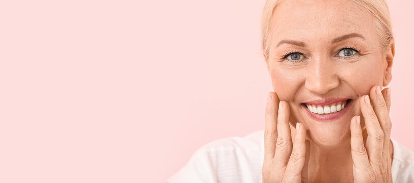 Beautiful mature woman on pink background with space for text