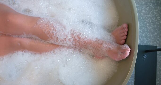 Lower legs and feet are shifting, curling, lifting after settling in tub with bubbles for comfort