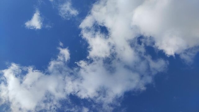 Un cielo de azul con varias nubes de color blanco  con un movimiento lento