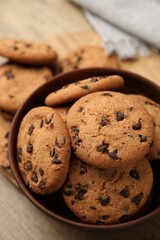 Delicious chocolate chip cookies in bowl on table, closeup