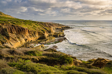 2025-10-23 THE RUGGED COASTLINE AT POINT LOMA IN SAN DIEGO CALIFORNIA WITH NICE GREEN FOLIAGE AND WAVES COMING ON SHORE WITH A NICE CLOUDY SKY
