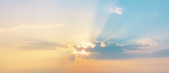 Obraz premium Beautiful cloudscape with sun rays and orange evening light at sea sunset