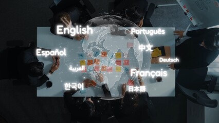 Aerial view of a diverse group engaged in a business meeting, showcasing various languages displayed on a world map, symbolizing global collaboration and communication. Raster