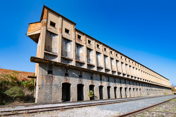 Fototapeta premium Old industrial buildings next to abandoned railway