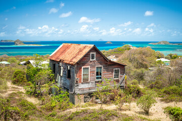 Abandoned and derelict traditional wooden clapboard cottage on Carriacou, Grenada