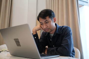 A man is sitting at a table with a laptop open in front of him