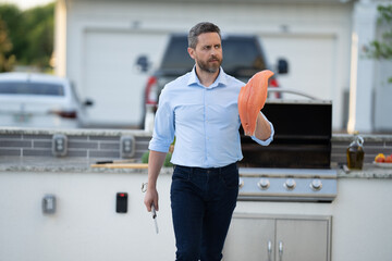 Barbecue and grill. Roasting and grilling food. Chef man do BBQ fish. Man cook salmon in the kitchen. Cooking fish in backyard. Handsome Hispanic man grill salmon barbecue