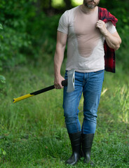 Strong man work in forest. Man in forest with axe. Lumberjack carries axe. Deforestation. Cropped view sweating man with axe. Lumberjack in woods with ax. Lumberjack tired with heavy axe