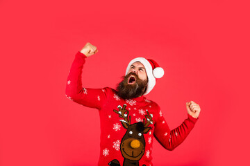 Christmas Sales. mature hipster wear knitted sweater. brutal bearded man in santa claus hat. merry christmas. man with beard on red background. happy new year. xmas shopping sales