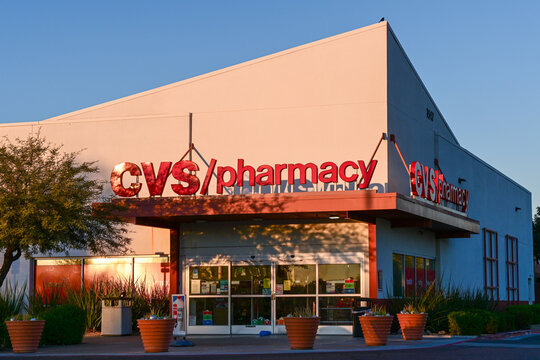 A CVS Pharmacy storefront at sunrise with illuminated signage and glass entryway, illustrating retail pharmacy operations and commercial healthcare services
