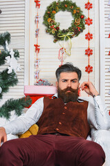 Man in Santa hat at Christmas. Merry Christmas. New Year holiday. Bearded retro man on Xmas. Happy New 2026 Year. Christmas party celebration. Xmas holiday in winter. Santa Claus relaxing at home