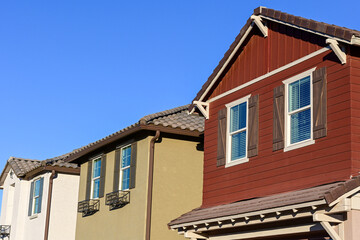 Close-up view of newly built two story homes with finished exteriors, illustrating modern residential construction, architectural detailing, and contemporary suburban housing design