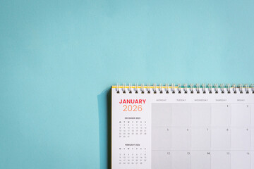 January 2026 Calendar lying flat on top of light blue paper surface. Copy space.