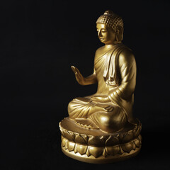 golden buddha statue on black background