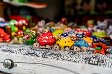 Fototapeta premium Handmade colorful ceramic turtle crafts displayed on a market table in Peru, with vibrant designs and playful artisan details.