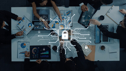 A business team collaborates on data security strategy with laptop displays, charts, and digital lock symbols, emphasizing innovation and protection in the workplace. Trope