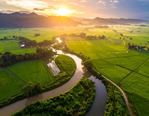 Aerial view of a lush green valley with a winding river at sunrise