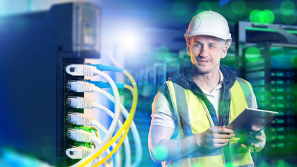 Network technician inspects data center connections, checking Ethernet cabling and monitoring server infrastructure with a tablet to maintain stable and secure IT network operations.