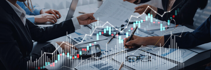 A collaborative business meeting showcasing professionals analyzing financial data with graphs and charts in a modern office setting, emphasizing teamwork and strategy for growth. Scalp